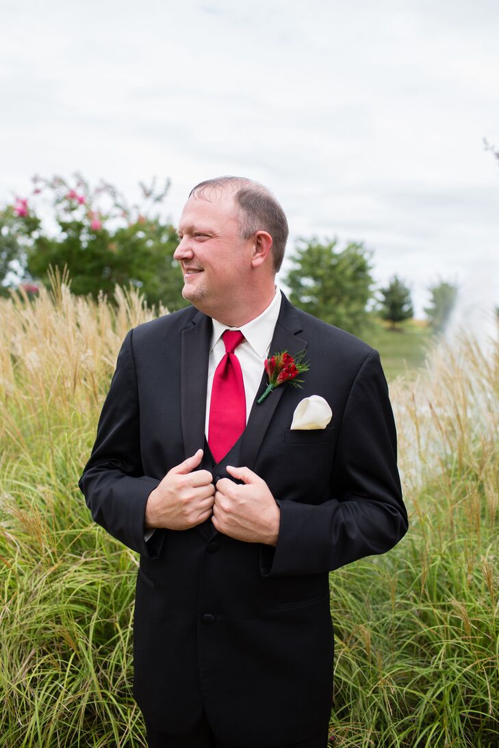 Chris wore a classic black tuxedo with a red tie and a red alstroemeria boutonniere pinned to his jacket above his ivory pocket square.