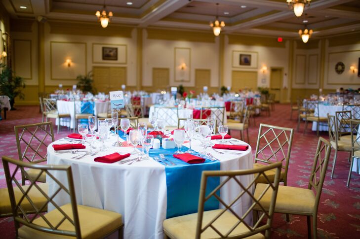 Dining tables at the reception were dressed in white tablecloths with teal table runners, accents with red napkins.
