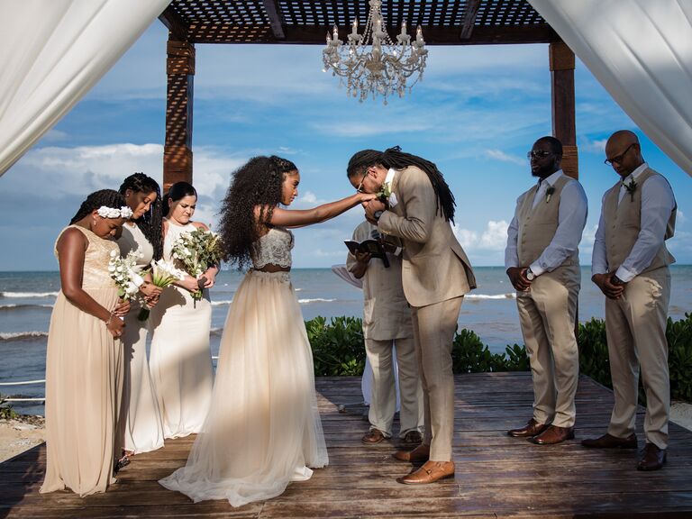 Groom kissing brides hand at ceremony
