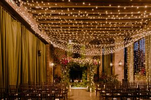 Romantic, Industrial Ceremony Site with String Lights and Flower Arch