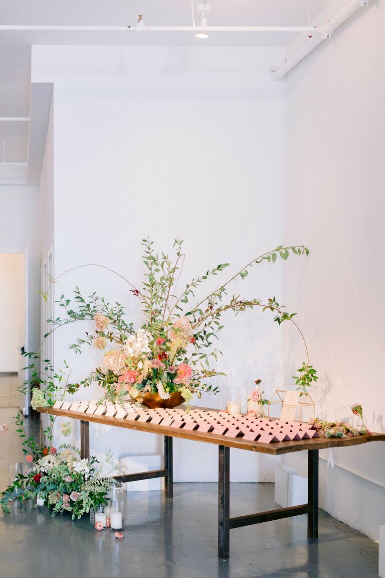 Escort cards and large floral arrangement on table