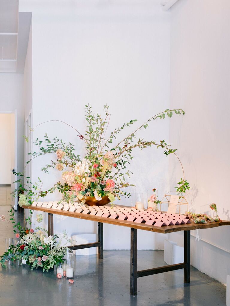 Escort cards and large floral arrangement on table