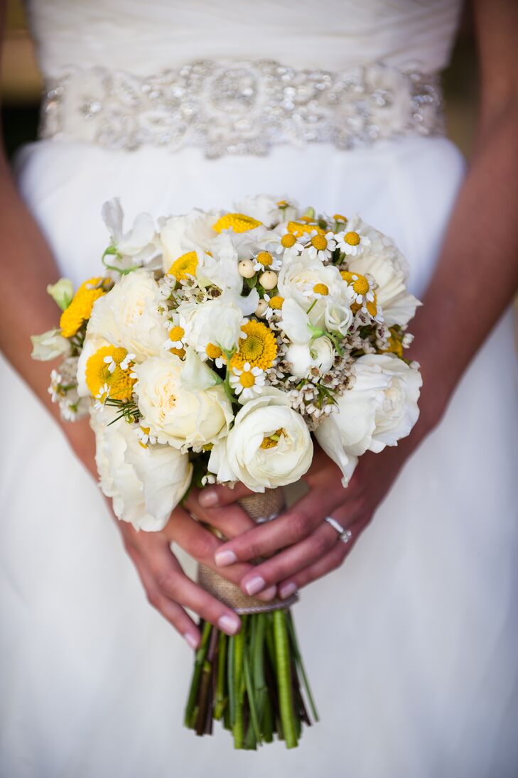 Sarah's bouquet looked as if she had just walked through a field and swept it up on her way to the ceremony. The arrangement of white and yellow blooms looked a little wild and matched her natural wedding theme.