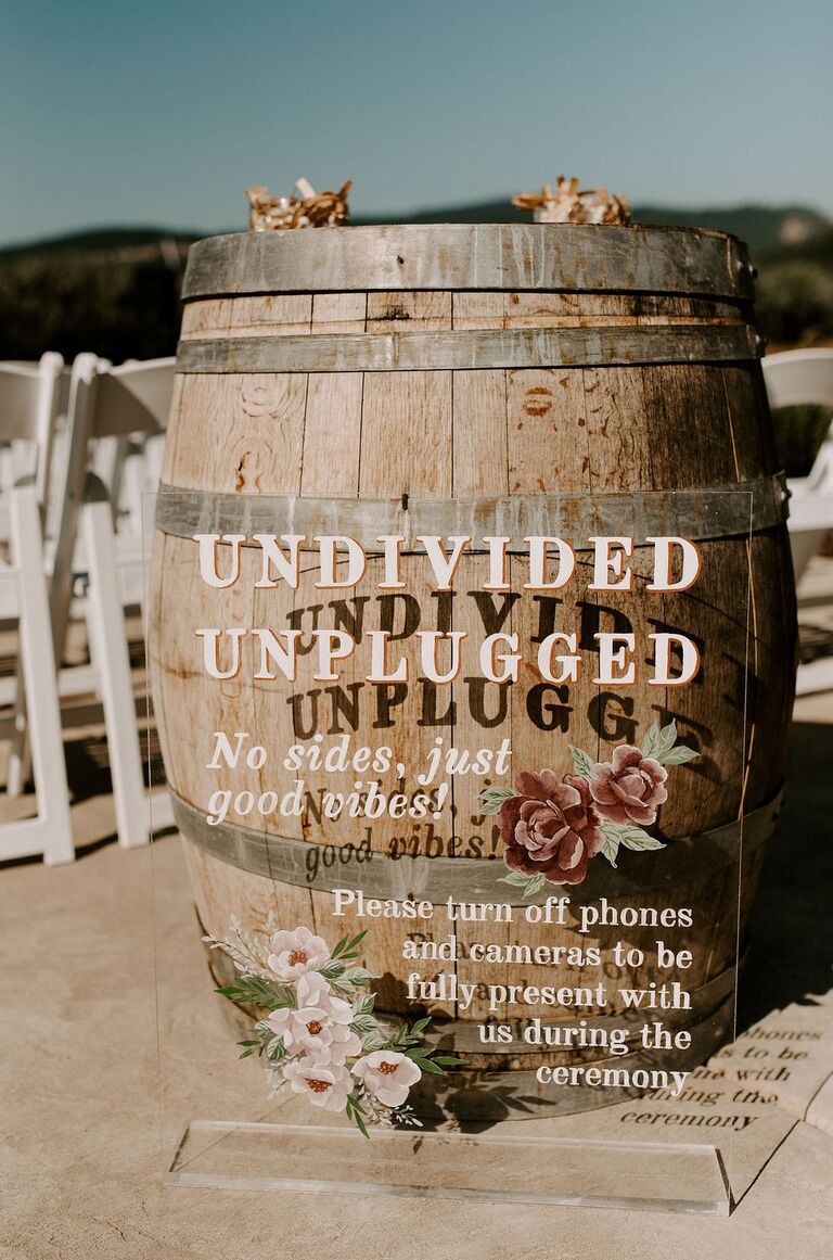 Acrylic sign beside rustic barrel