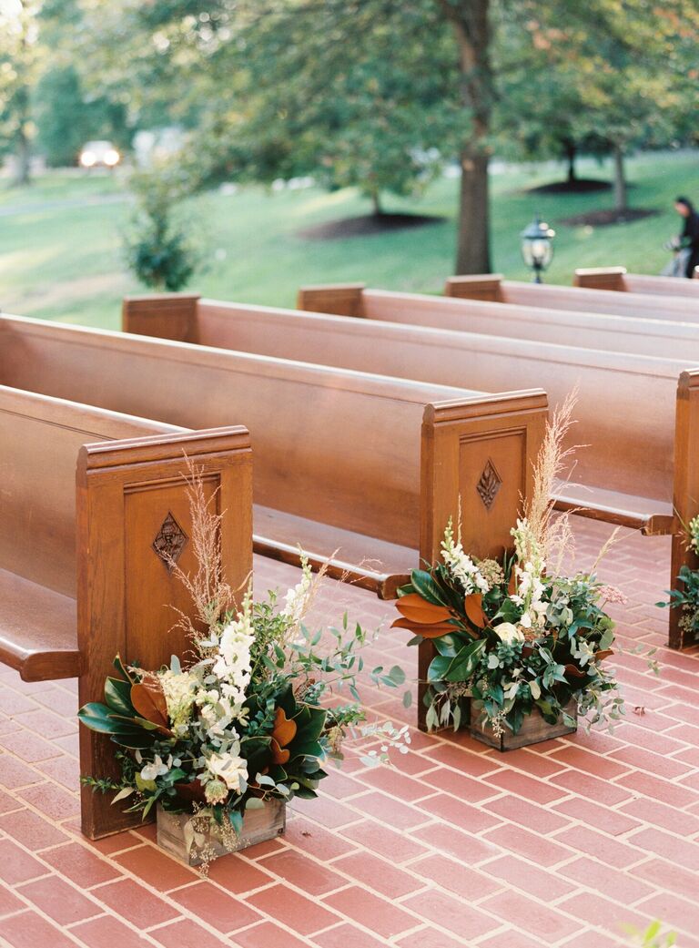 Wood pews with magnolia leaf arrangements