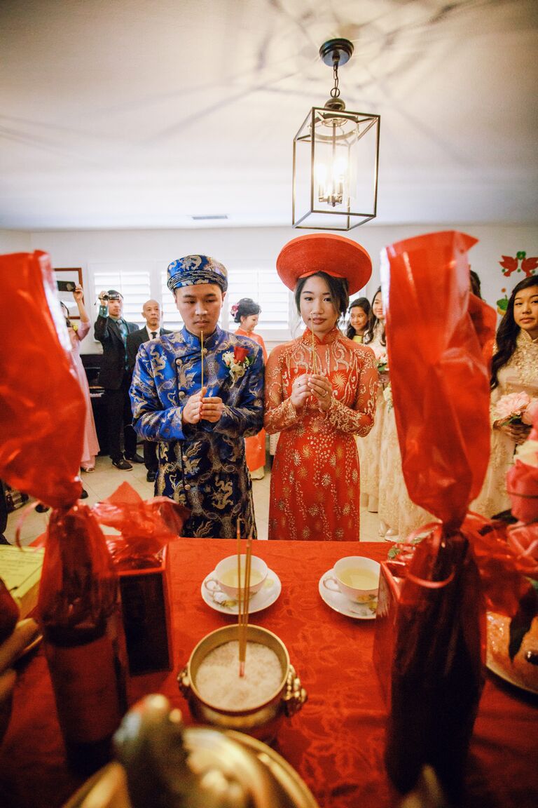 Couple praying at altar during Vietnamese wedding ceremony