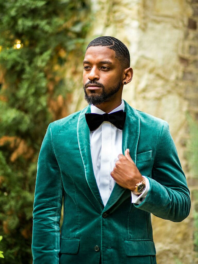 Groom wearing emerald green velvet tux with black bow tie