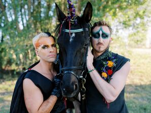 Grooms With Colorful Makeup Posing With Black Horse
