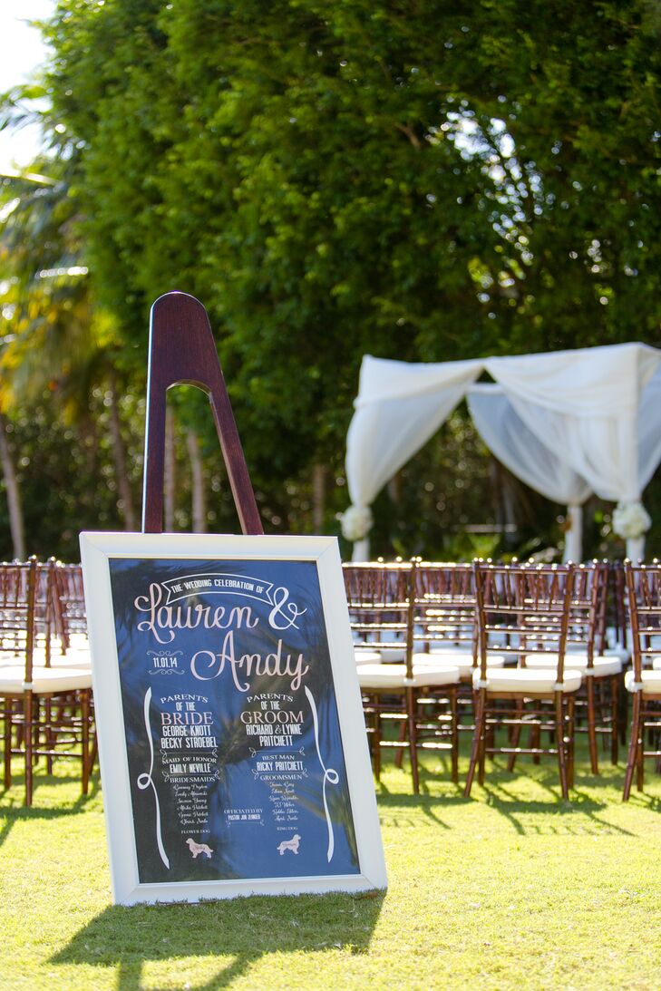 Instead of handing out programs, Lauren and Andy had all the ceremony information in one spot. A chic black, white and blush sign was placed at the head of the ceremony space. It had the names of those involved in this chic script with ribbon-inspired details along the sides.