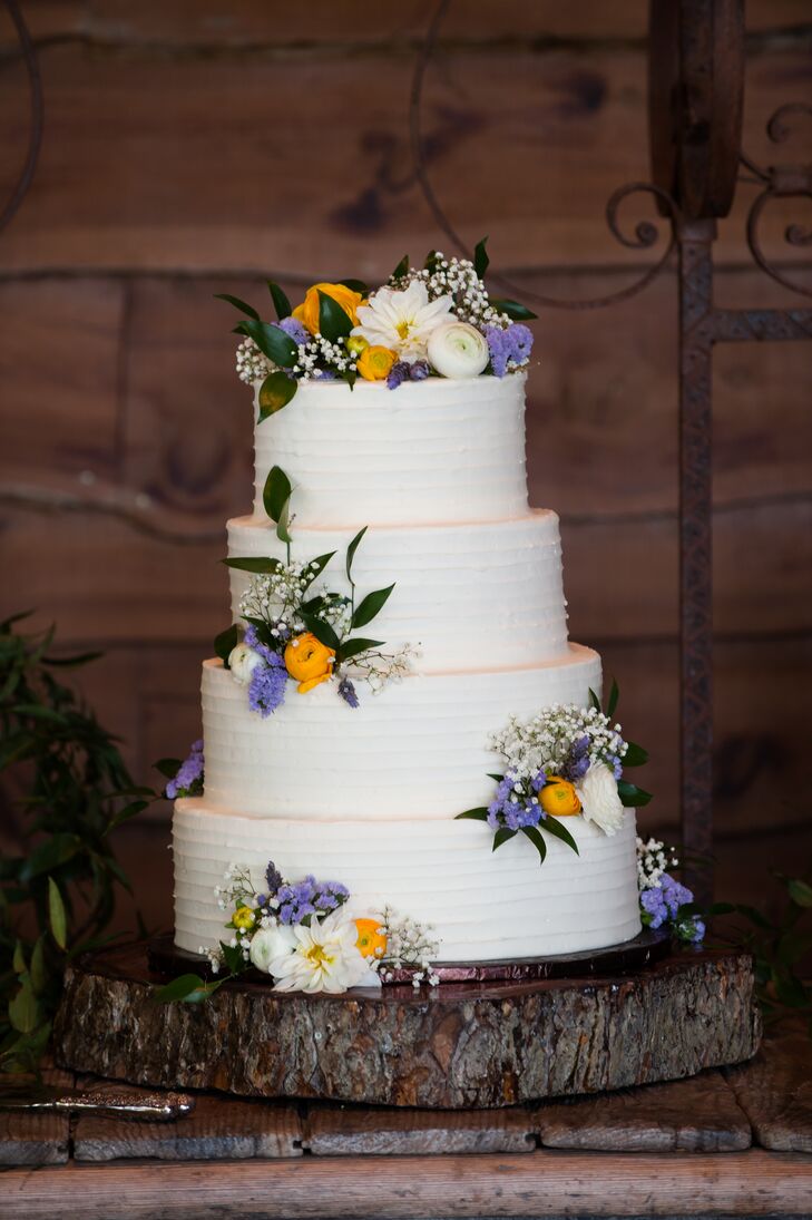 Going along with the wildflower theme, this wedding cake had scattered yellow, white and blue flowers with greenery to complete the natural look.