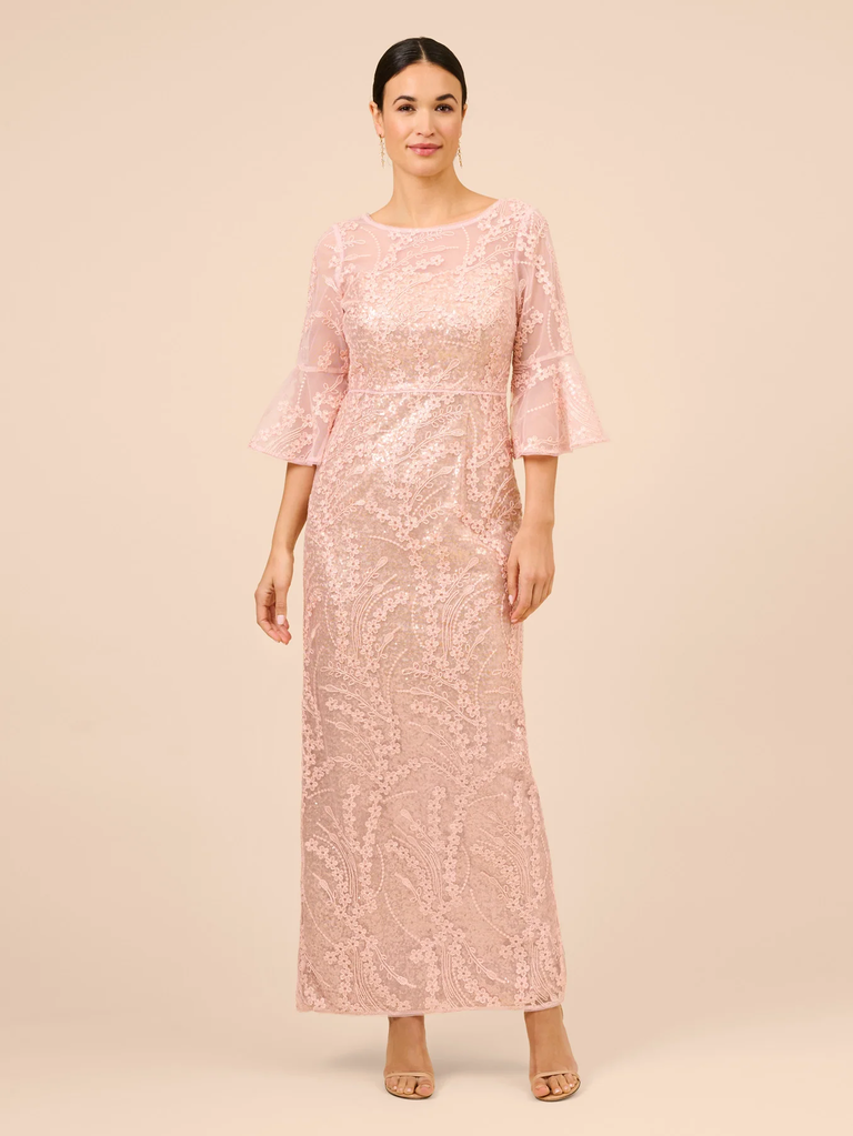 A model shows off this pale pink, floor-length mother of the bride gown.