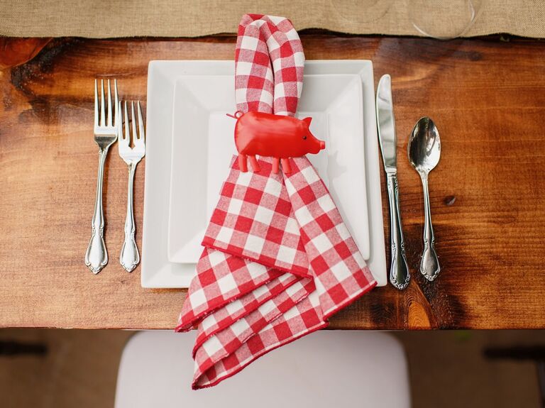 BBQ wedding place setting with red checkered napkin and pig napkin ring