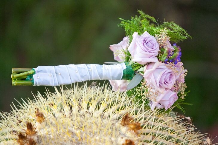 Stephanie carried a purple bouquet with long stems wrapped in white fabric.