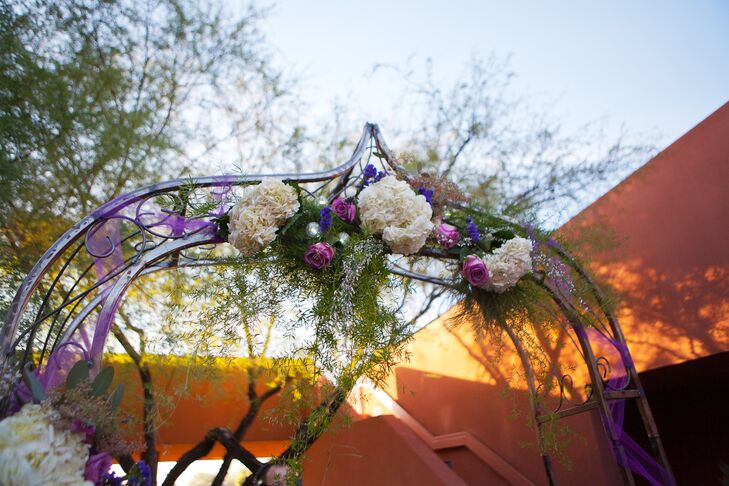 Stephanie and Bobby were married under a wedding arch decorated with romantic white and purple florals and greenery.