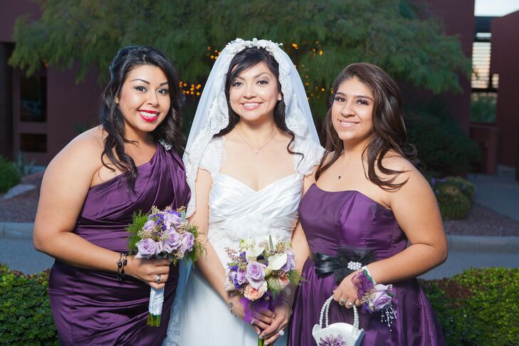 Stephanie's bridesmaids and flower girl wore purple gowns in different styles and carried lighter purple rose bouquets.