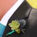 The groom wore a bright green succulent and blue thistle wrapped up in turquoise ribbon as his boutonniere on his wedding day.