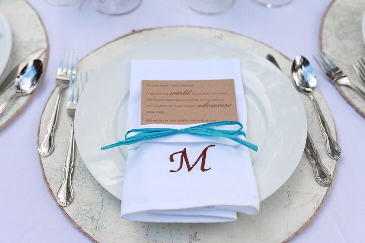 Simple ivory plates were topped with crisp white napkins and accented with neutral menu cards and a pop of turquoise in the ribbon that tied everything together.