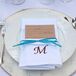 Simple ivory plates were topped with crisp white napkins and accented with neutral menu cards and a pop of turquoise in the ribbon that tied everything together.
