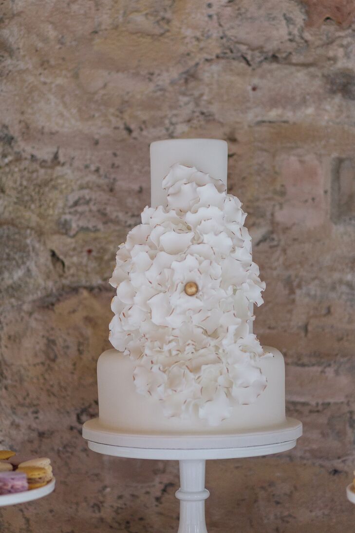 Elizabeth’s penchant for modern design featured prominently in the couple’s wedding cake. Three towering layers of white fondant-covered cake gave way to a textural fondant flower sculpted in the likeness of a hydrangea. Gold paint placed at the edges of the sugary creation added a hint of glamour and drama to the confection.
