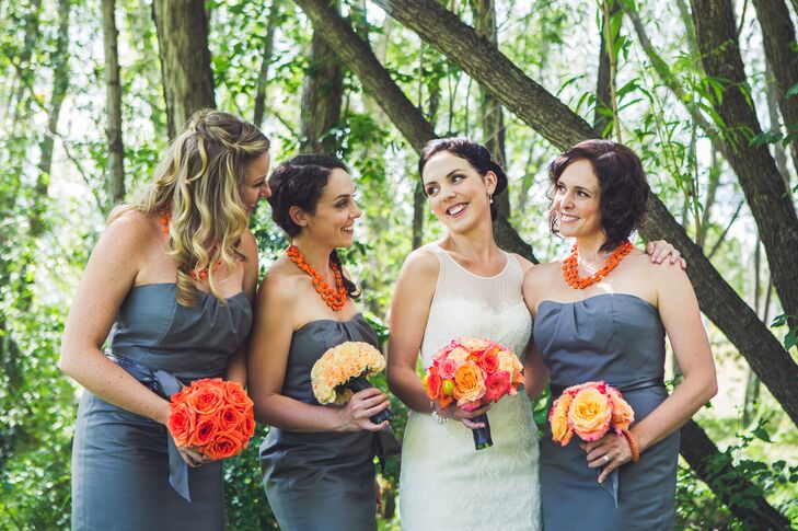 The bridesmaid's gray strapless dresses perfectly complemented the bright orange bouquets they carried.