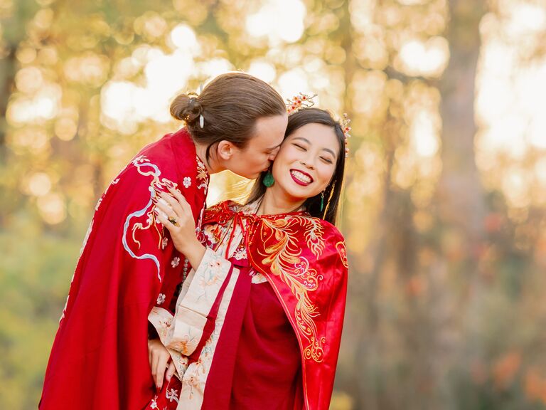 Bride and groom in Chinese wedding kissing on the cheek