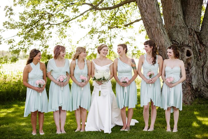 Bridget shared a happy moment with her bridesmaids, who stood around her wearing mint green dresses in a variety of styles.