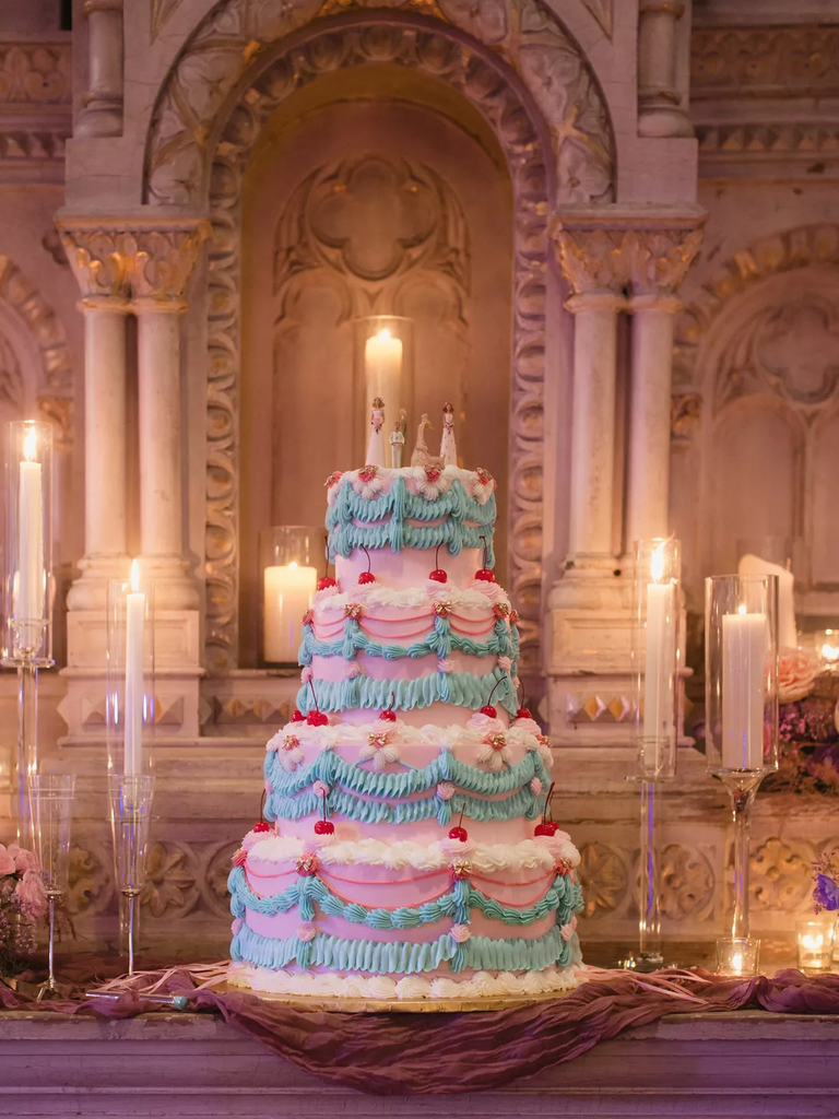 Fun and festive pastel four-tiered wedding cake with toppers