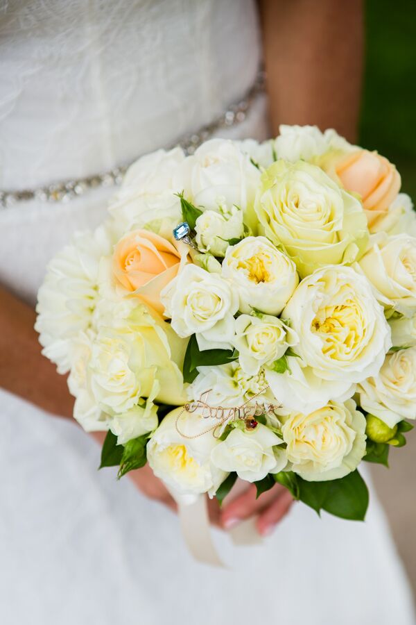 Michelle held a gorgeous round bouquet filled with garden roses and spray roses in shades of peach and white. "Inside my bouquet, we secured my 'something old,' a brooch from my nana (paternal grandmother), and my 'something blue,' which was a family ring from my husband’s mother," Michelle says. "The bouquet base was wrapped with my 'something borrowed,' fabric from my mother’s wedding dress."