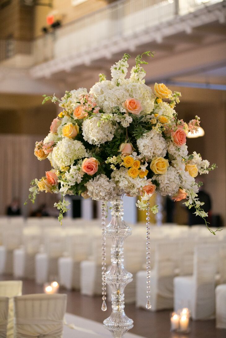 While elegant and romantic, the ceremony decor was relatively traditional and understated, so it wouldn't overwhelm the beauty and grandeur of the historic space. Zak Events designed several lush, textured arrangements of white hydrangeas, peach roses and pink stock to sit atop tall crystal stands, which were placed at the entrance to and along the sides of the ceremony space. The floral arrangements played up the height of the room, while subtly adding to its striking features. “All the beautiful architectural aesthetics aside, it was really all the history and stories living inside that room that made every moment of our wedding feel so extraordinary,” Lauren says.