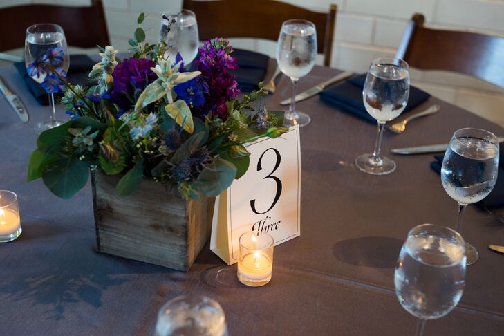 Centerpieces at the reception were made up of wooden boxes that were filled with arrangements of purple stock, purple roses, dusty miller and greenery.