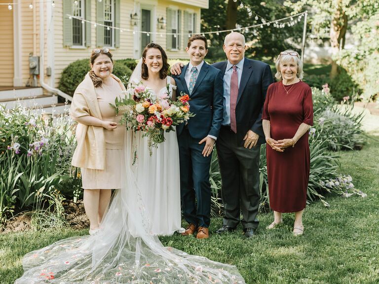 Newlyweds with family members at summer wedding