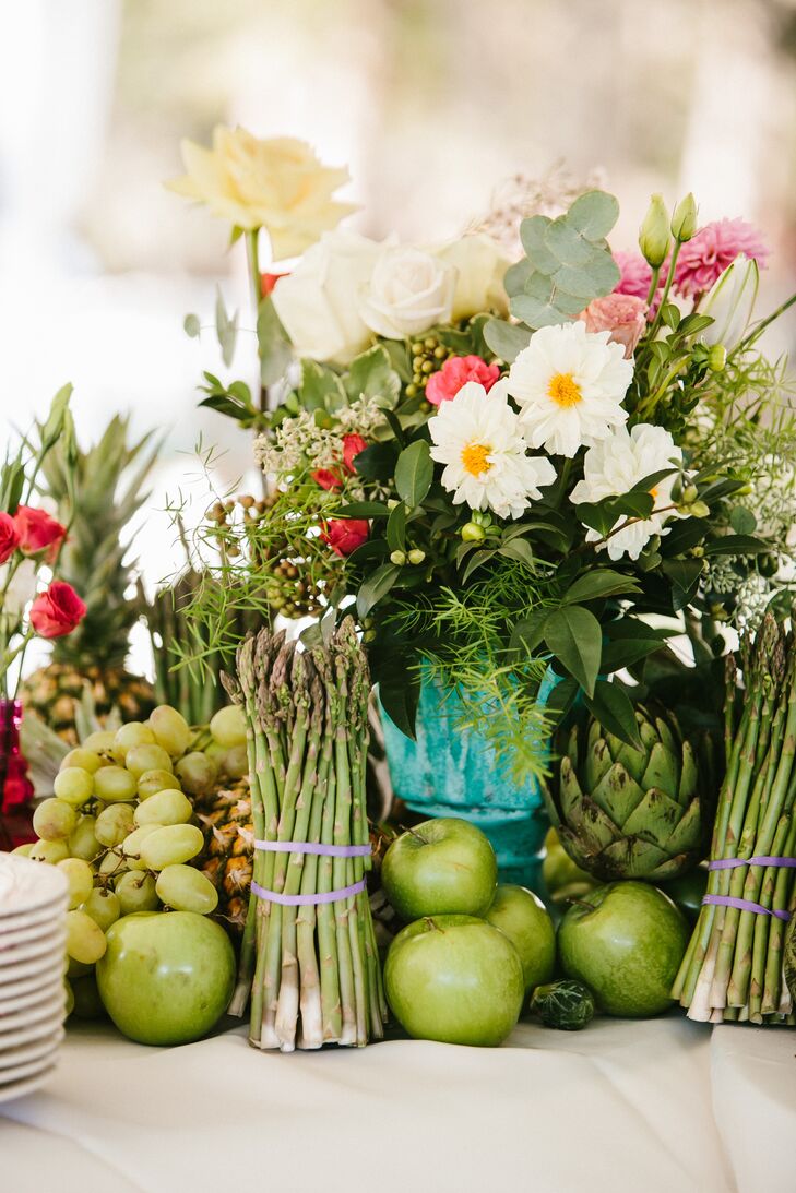 The couple brought more vibrant colors into their tented reception with an array of fresh fruit, flowers and vegetables displaced in an eclectic mix of vases.