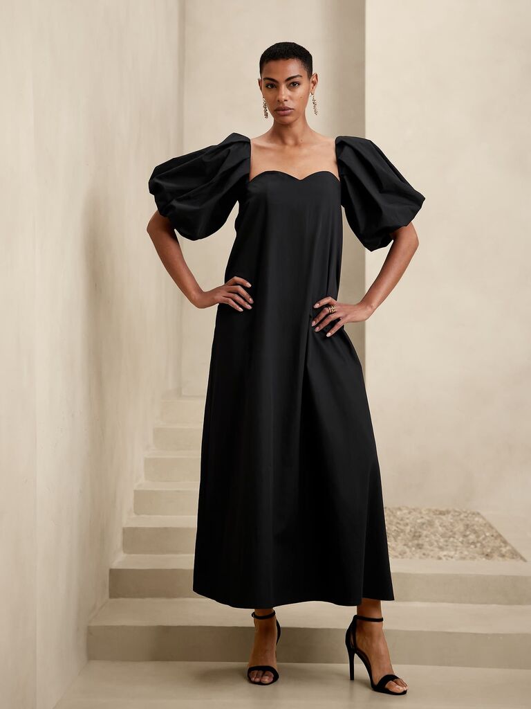 Model wearing a black puffed sleeved maxi dress