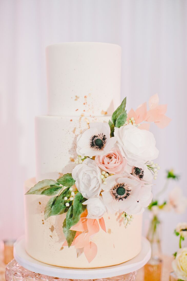 Patricia and Christopher’s wedding cake by Heythere, Cupcake! was a confectionary dream. A cascade of anemones, lisianthuses, ranunculuses and greenery decorated the center tier, while the bottom layer was adorned with sparkling rose gold glitter.