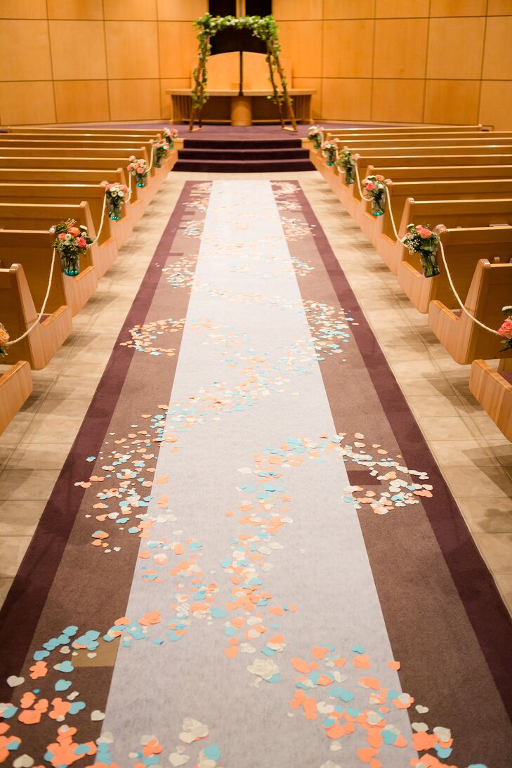 At the ceremony, the flower girls spread colorful heart-shaped paper as they walked down the aisle. The couple hand cut all of the paper, and Charles built the wood wedding arch garnished in garland.