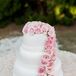 Great Cakes created this three-tier confection for dessert. Each tier was decorated with white pearl-style detailing around the bottom. Lots of pink roses topped the cake and cascaded down the side for added romance.