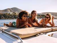 3 women laying out on beach and laughing