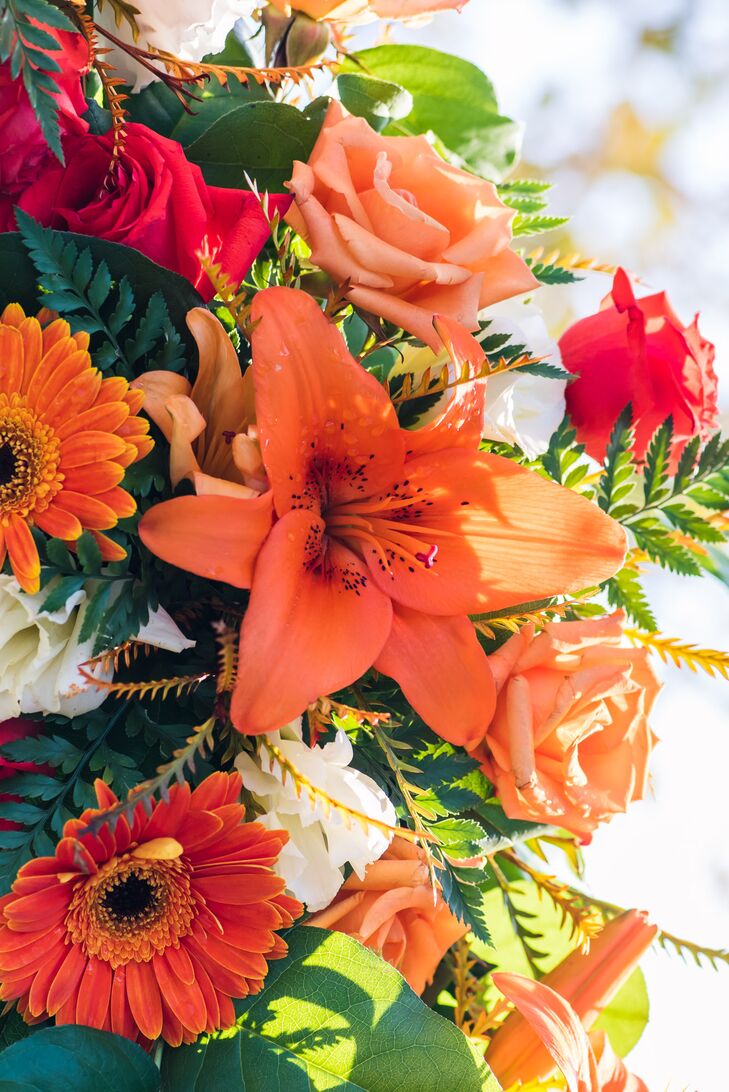 The bouquets were gorgeous mixture of orange, red with accents of white and green, standing out against the charcoal dresses and suits.