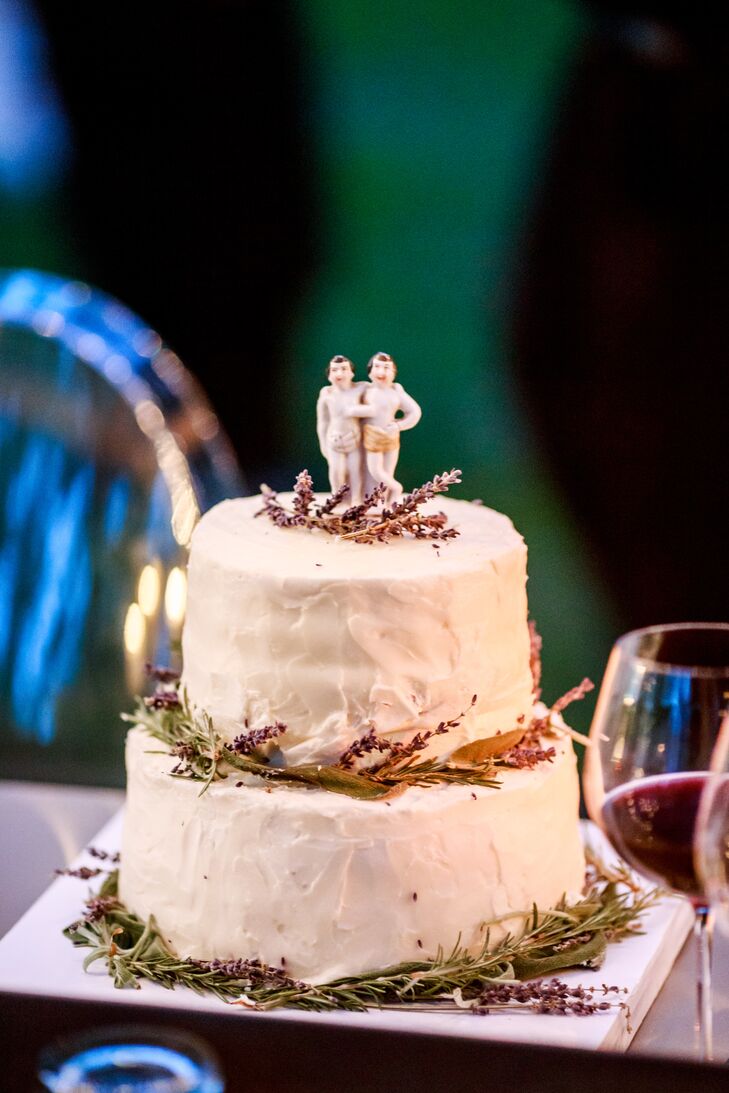 Rustic florals and a whimsical two-groom cake topper minimally decorated a simple two-tier wedding cake coated in buttercream.