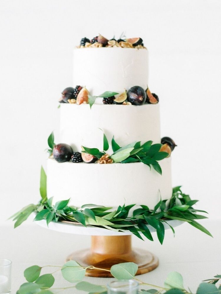 three-tier wedding cake with greenery and fresh figs