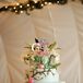 Julie and George designed their wedding cake with the help of Granite Bakery. The sky blue three-tier cake on a wooden slab had a tree climbing up the tiers with edible pink flowers and green leaves to give it a colorful, natural look. Fresh flowers and a bird topper completed the cake.