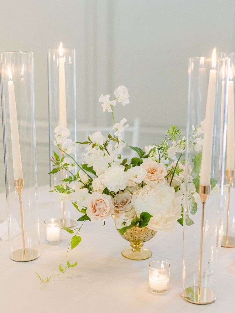 rose and sweet pea floral centerpiece with ivory taper candles
