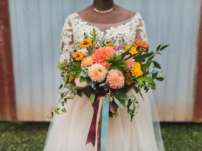 Bride holding colorful dahlia bouquet 