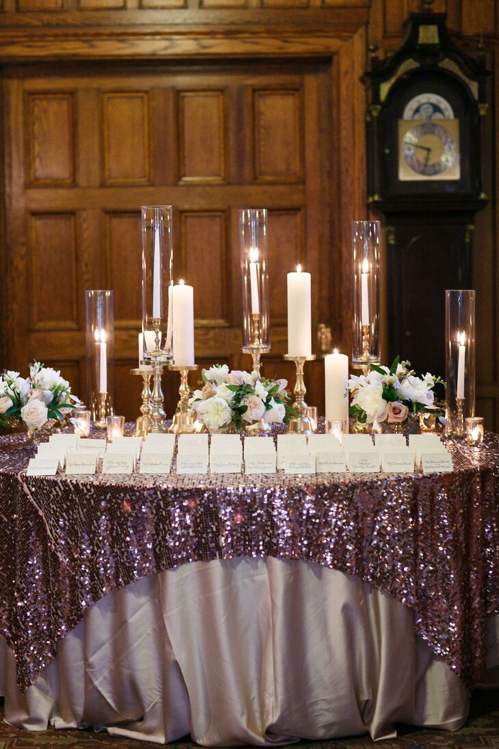 With such a bold design, guests were sure to see the couple’s entrance table. They placed each ivory calligraphy card from Magnificent Milestones on bold purple sequin and satin linens. Tiered white candlesticks, tealight candles and lush bouquets surrounded every row, creating a glamorous display.