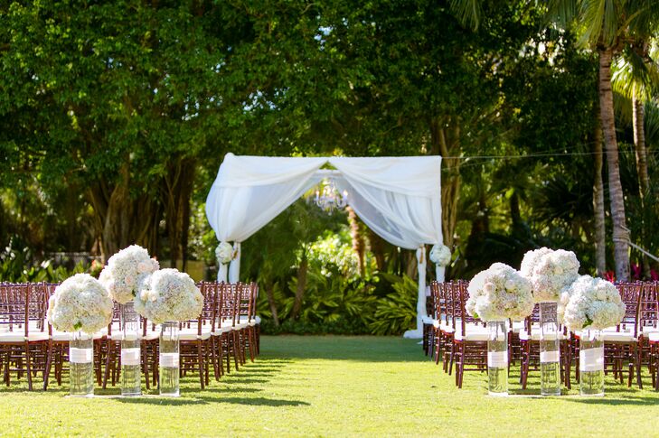 While the flower arrangements were among the hardest decisions for Lauren and Andy to make, the result was nothing short of classic. They had a trio of white hydrangeas with a hint of pink and blush garden roses on both sides of the aisle. Each one stood atop a glass cylinder vase with white ribbon wrapped around the center like a chic present.