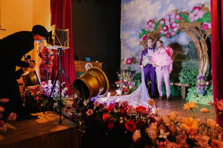 Grooms in Bold Outfits Posing Together on Stage at Custom, Whimsical Photo Booth, Theater