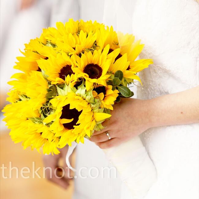 Robyn carried a bouquet of sunflowers wrapped in white fabric to complement her gown.