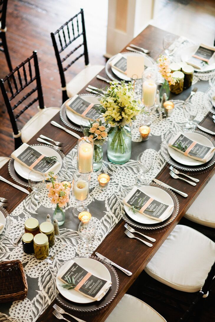 The reception tables were topped with gray and white linen table runners that added a little elegance to the wooden tables. They were topped with roses, stock and dusty miller in glass vases, along with pillar candles for an extra pop of color and romance.