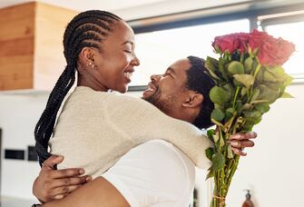 Husband and wife embracing after gifting her flowers