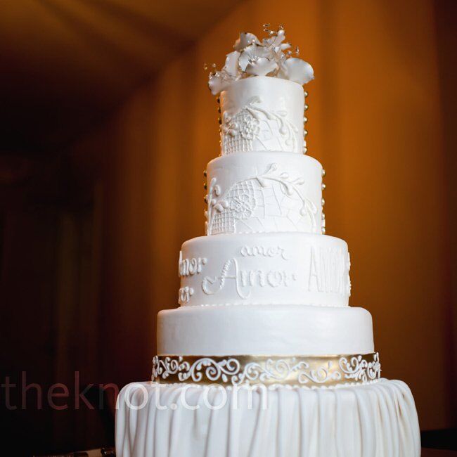 To incorporate the couple’s theme, the four-tiered wedding cake was decorated with hand-painted lace designs and Spanish words like amor.